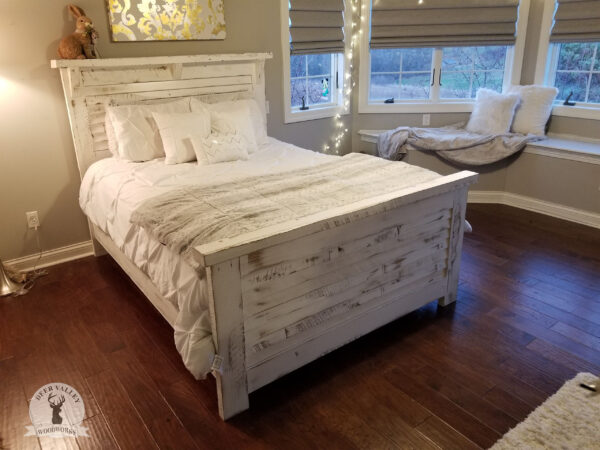 Farmhouse bed with whitewashed barnwood shiplap clapboards on the headboard and footboard, connected by bedrails.
