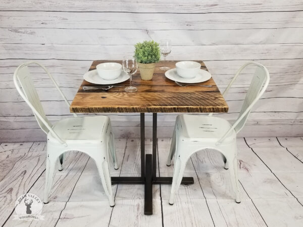 Barnwood bistro table with thick square barnwood top on a welded steel base finished with an antiqued patina.