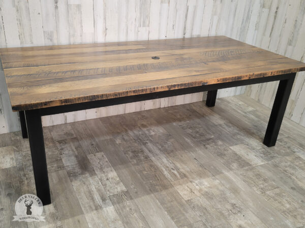 Rustic authentic barnwood table with large top and blackened welded steel frame and legs.