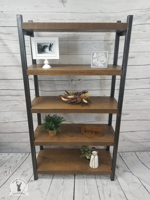 Reclaimed wood free-standing bookshelf with a walnut stain with five heavy duty shelves and blackened vertical uprights made from steel with fully welded shelf supports.