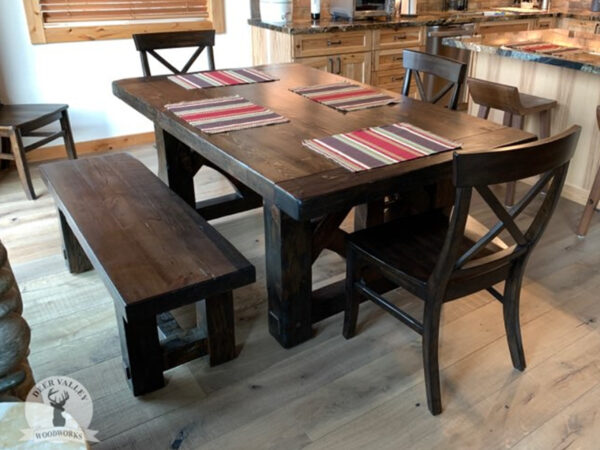 Farmhouse dining table with thick reclaimed wood tabletop with pinned mortise and tenon breadboard ends and pinned 5" thick legs with through tenons.