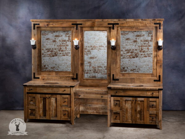 Dual rustic barnwood vanities, each with six drawers and a pair of barnwood doors in the center, connected by a sitting makeup area with large center drawer and on top are three large framed mirrors with knick-knack shelves, antique mounting brackets and crown moulding.