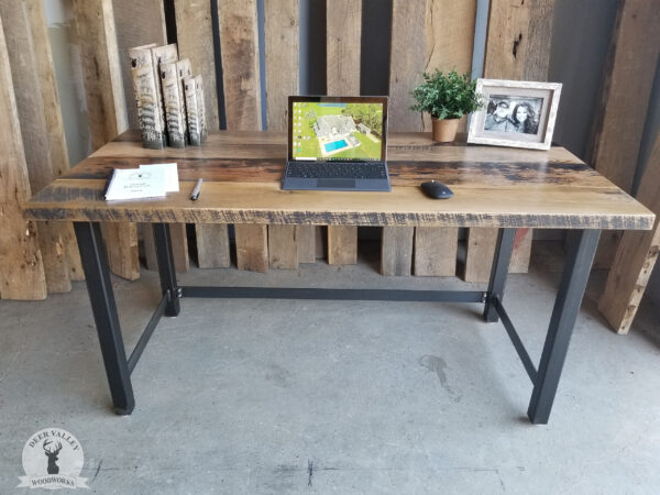 Rustic barnwood straight desk with a deep reclaimed wood desktop on blackened welded steel legs.
