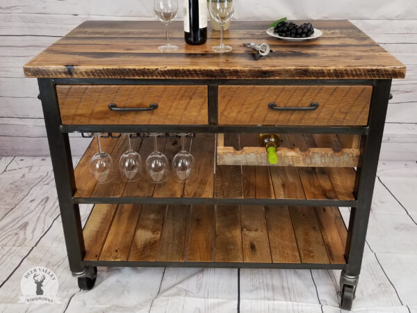 Rustic authentic barnwood beverage cart with a large barnwood top, two drawers and two large shelves, two industrial towel bars, stemware rack, four-bottle wine holder rack and an antiqued blackened steel frame and casters.