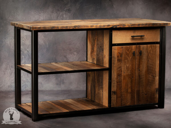 Rustic reclaimed barnwood buffet table with a solid reclaimed wood top, two barnwood slat shelves and a large wood drawer with a large cabinet with barnwood doors below all surrounded by a blackened welded steel frame.