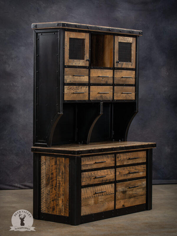 Modern industrial hutch, with upper section with six drawer, two small cabinets with wire mesh doors, an open cubby in the center, all capped with a riveted steel, and a lower section with two regular drawers, four large drawers and a large barnwood top wrapped in a blackened riveted steel strap.