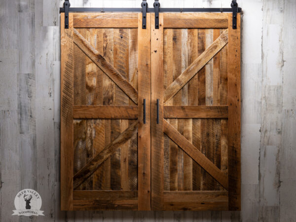 Rustic barnwood sliding doors with a true mortise & tenon door with black handles on black sliding hardware.