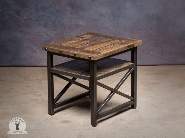 Industrial reclaimed barnwood end table with a Jacobean stain, full shelf, breadboard ends and steel rivet heads on a welded steel frame with X braces on each side.