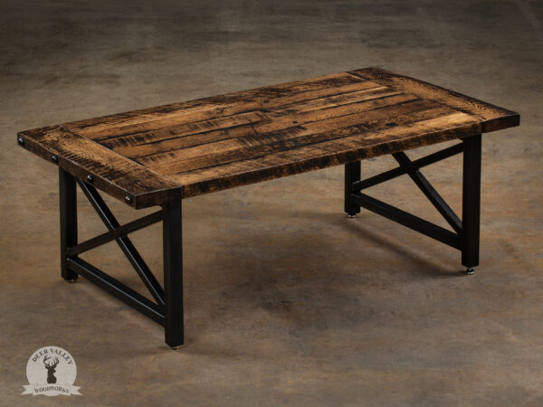 Industrial reclaimed barnwood coffee table with a Jacobean stain, breadboard ends and steel rivet heads on a welded steel frame with X braces on each side.